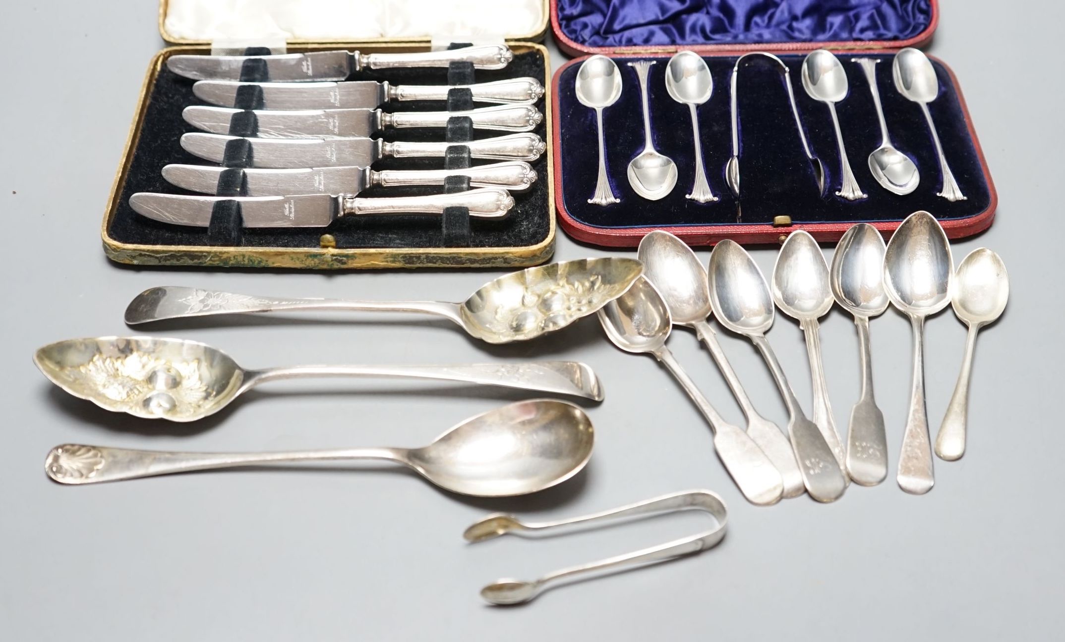 Two George III silver 'berry' spoons, seven other silver spoons, pair of silver tongs, a Swedish white metal teaspoons and two cased sets including silver teaspoons.